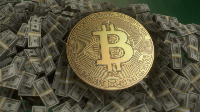 One_bitcoin_sitting_atop_bundles_of_US_100_notes.png